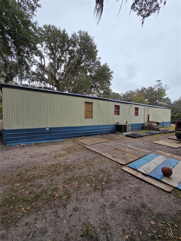 The exterior of a long, single-story mobile home with metal siding and blue skirting — 20 SW 3RD STREET, WEBSTER, FL