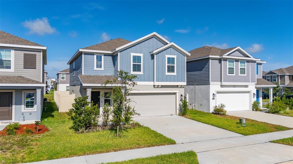 A two-story house with blue siding, a two-car garage, and a small front yard — 1334 DIEGO TERRACE UNIT A, WINTER HAVEN, FL