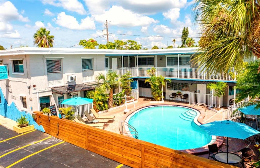 A two-story motel building with a swimming pool and patio area in the courtyard — 11965 GULF BOULEVARD, ST PETERSBURG, FL