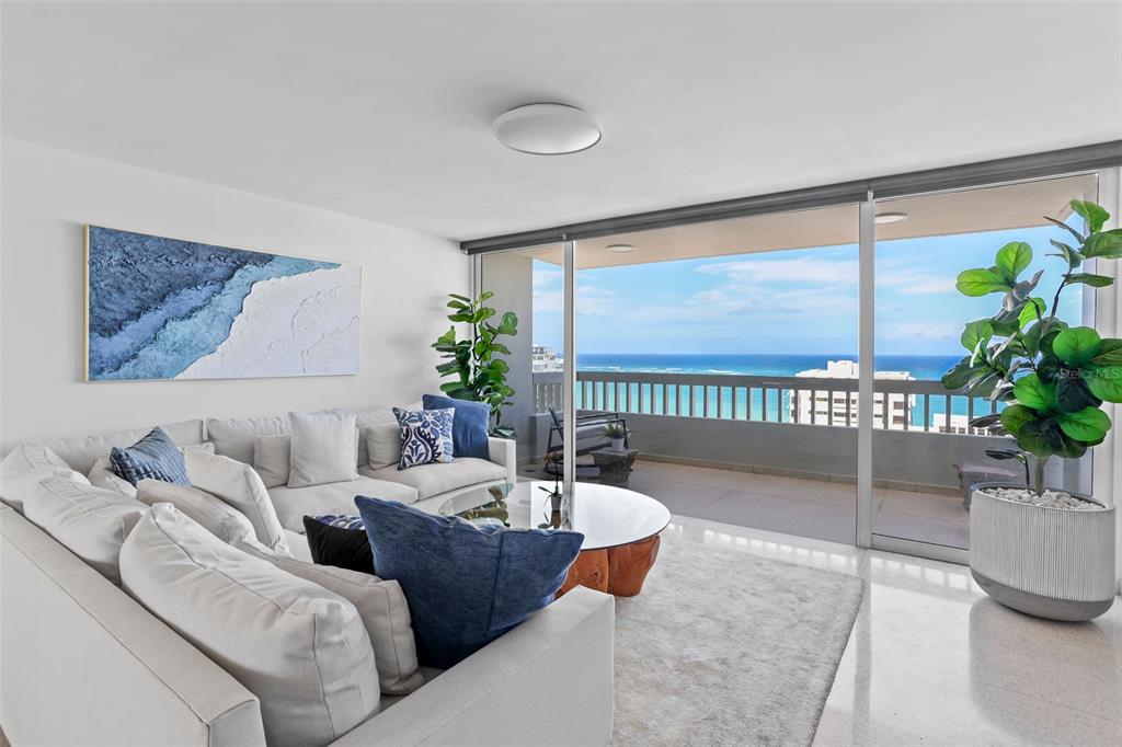 A living room features a white sectional sofa, a glass coffee table, and a balcony view — 70 KINGS COURT UNIT 17C, SAN JUAN, PR