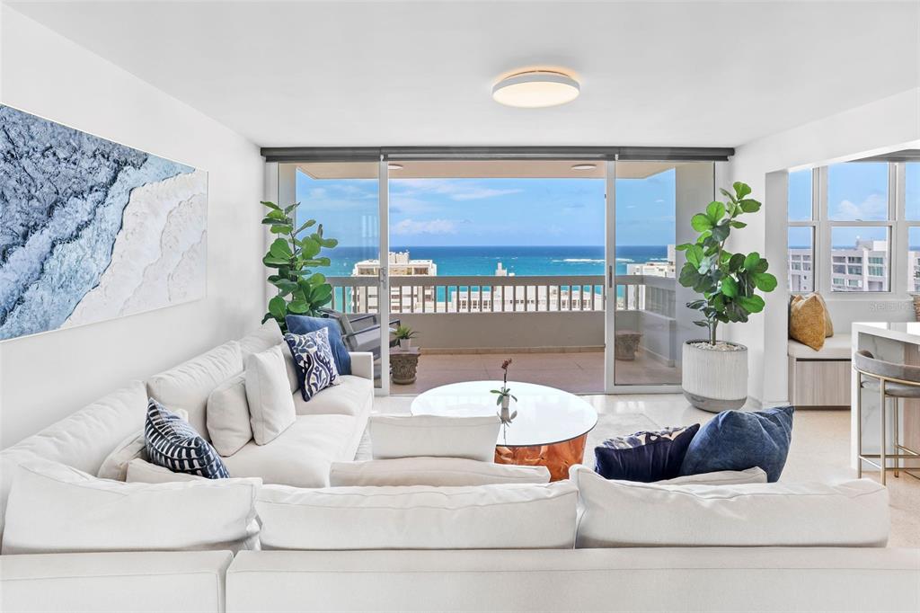 A white living room features a large sectional sofa, a glass coffee table, and a balcony — 70 KINGS COURT UNIT 17C, SAN JUAN, PR