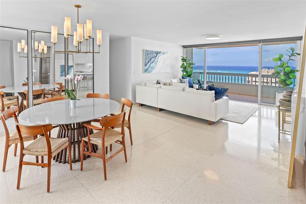 A bright, open-concept living and dining area features white tile floors and a balcony view — 70 KINGS COURT UNIT 17C, SAN JUAN, PR