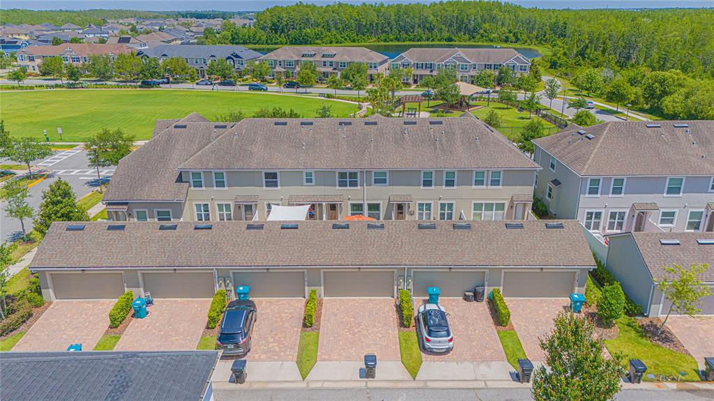 An aerial view of a multi-unit townhouse complex with attached garages and paved driveways — 10520 BURROWS STREET, ORLANDO, FL