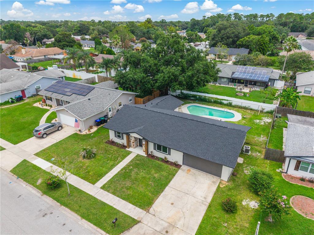 An aerial view of a suburban neighborhood featuring single-family homes with pools and solar panels — 8624 BAYLOR CIRCLE, ORLANDO, FL
