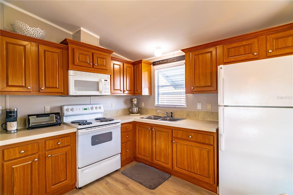 A dining area features a round wooden table, four chairs, a pendant light, and a window — 8320 RIVERSIDE DRIVE UNIT 51B, PUNTA GORDA, FL