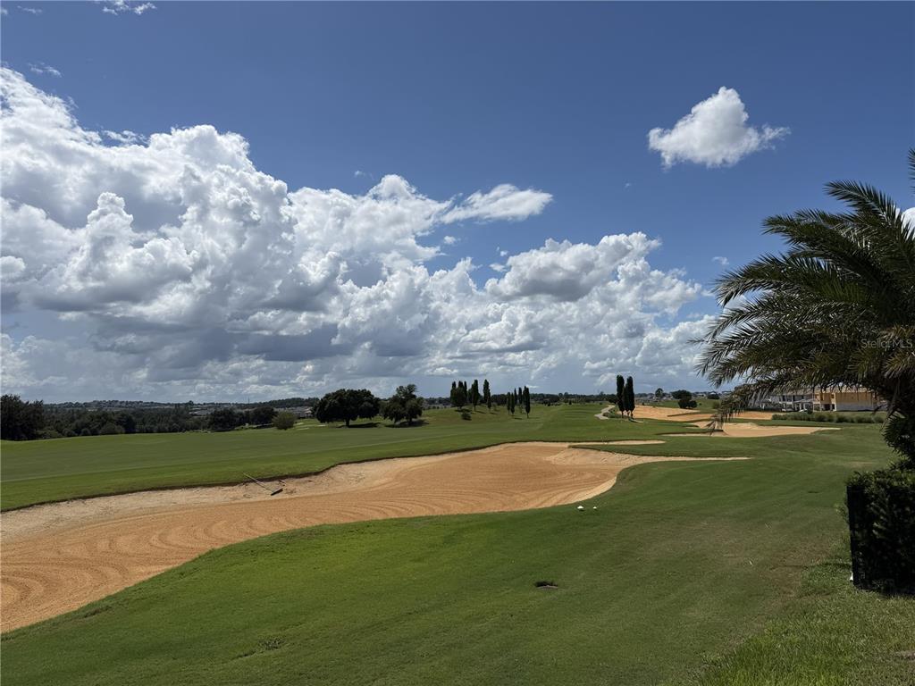 A view of a golf course fairway with sand bunkers and a palm tree — 15950 VETTA DRIVE, MONTVERDE, FL