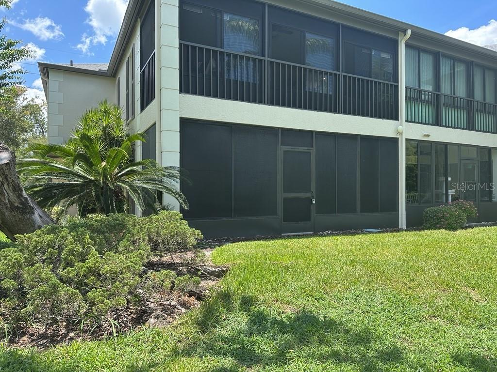 A two-story building features screened-in porches on both levels and a landscaped lawn — 13046 VILLAGE CHASE CIRCLE UNIT 13046, TAMPA, FL