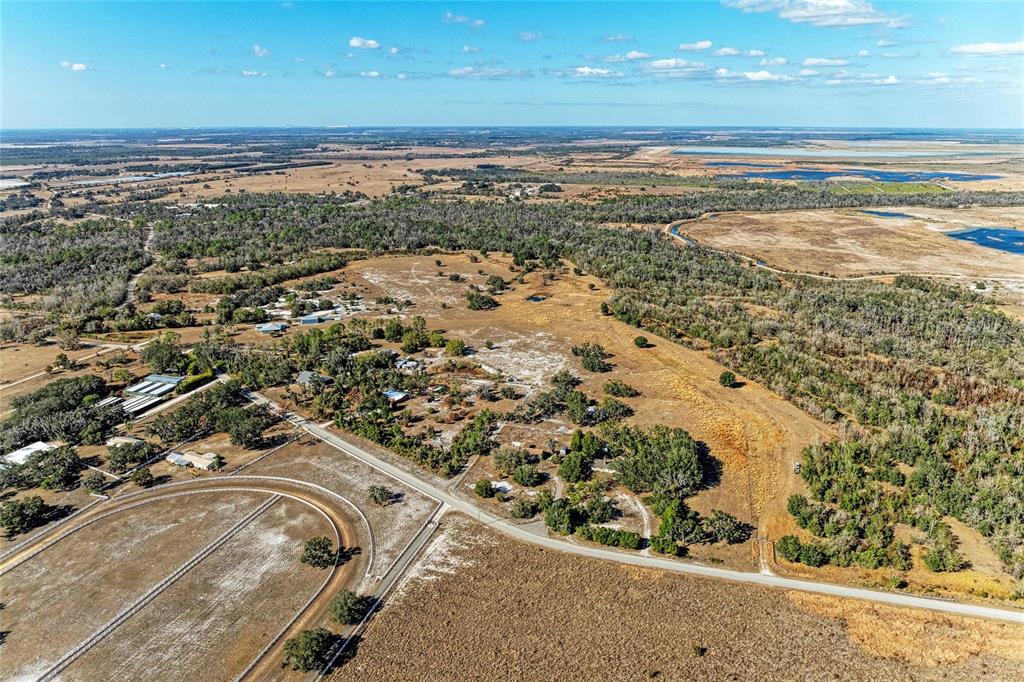 An aerial view shows a rural property with a horse track, buildings, and surrounding fields — 33100 & 33070 TAYLOR GRADE ROAD, PARRISH, FL
