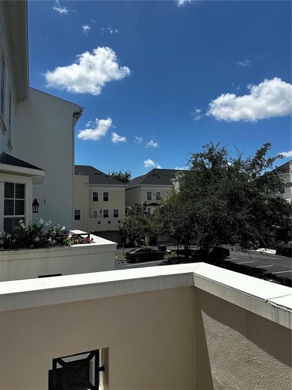 A view from a balcony overlooking a parking area and neighboring residential buildings — 1350 CHATFIELD PLACE, ORLANDO, FL