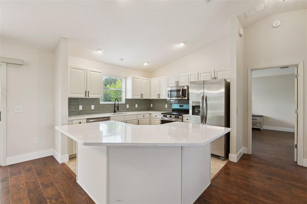 A screened-in patio features wicker furniture, a ceiling fan, and views of a grassy yard — 1575 HOLLYBERRY PLACE, THE VILLAGES, FL