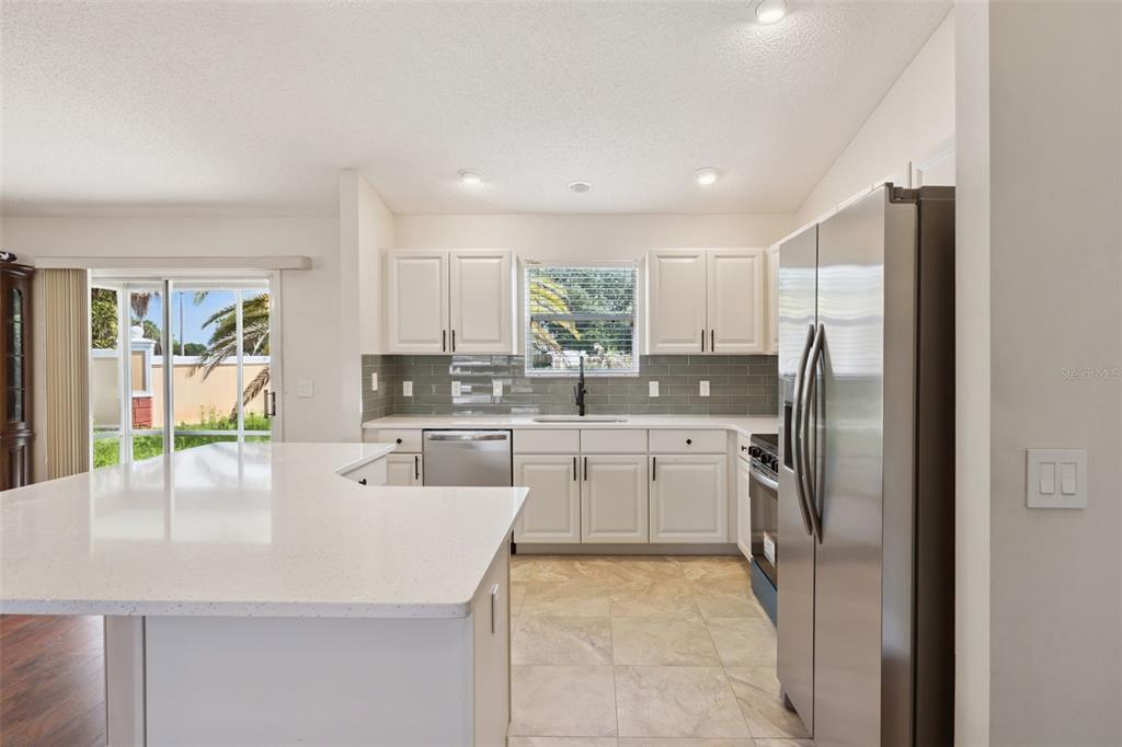 A screened-in porch with a ceiling fan overlooks a grassy backyard with a palm tree — 1575 HOLLYBERRY PLACE, THE VILLAGES, FL