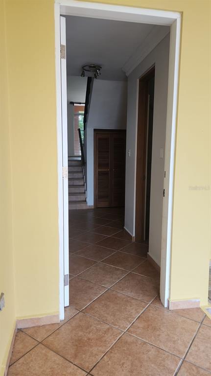 A doorway leads from a yellow room into a hallway with tiled floors and stairs — Harbour Drive Street PLAZA DEL PUERTO @ PALMAS DEL MAR DRIVE NE UNIT A-9, HUMACAO, PR