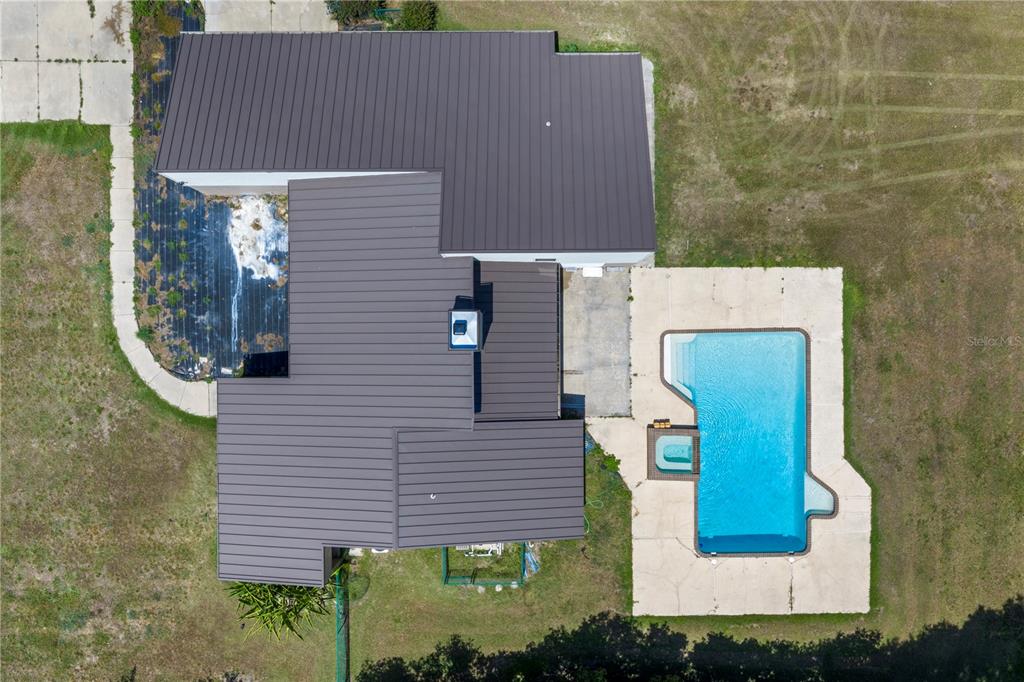 An aerial view shows a house with a metal roof, a pool, and a patio — 3261 SE 41ST PLACE, OCALA, FL
