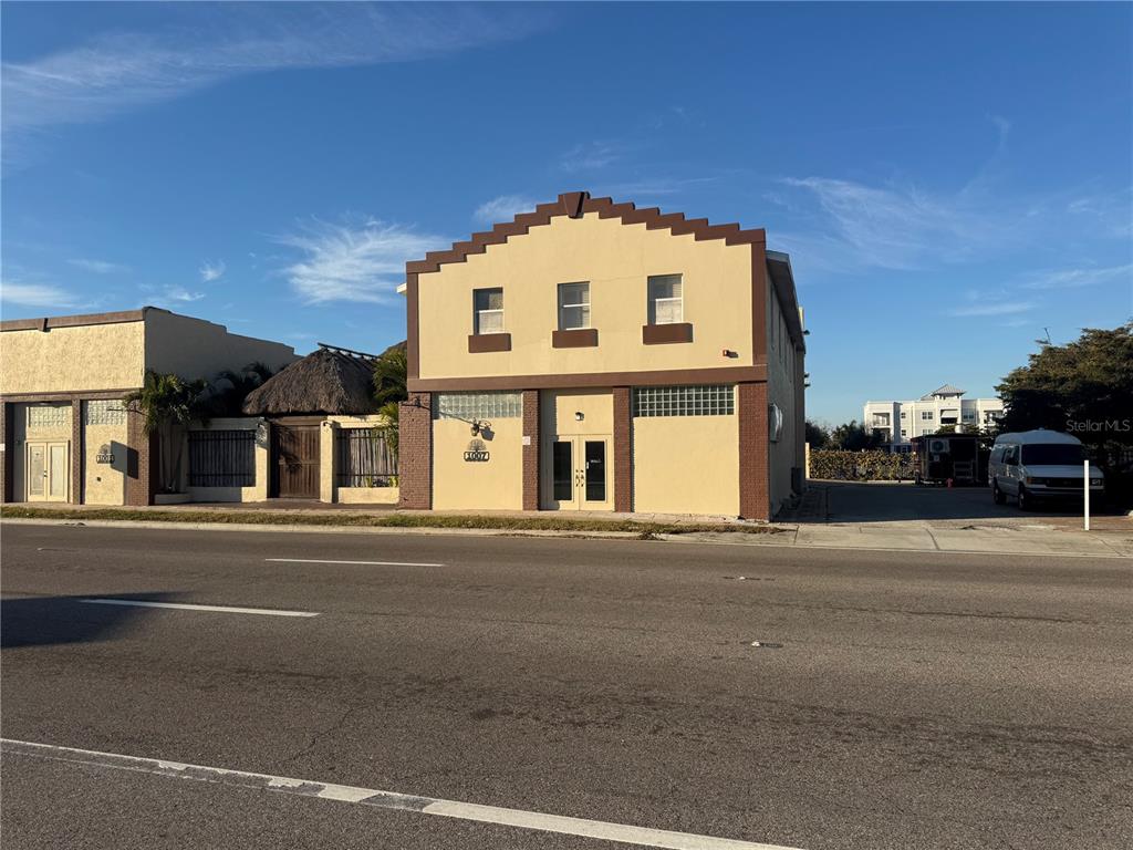 A two-story commercial building with a stepped roofline sits along a paved road — 1007 MANATEE AVENUE E, BRADENTON, FL