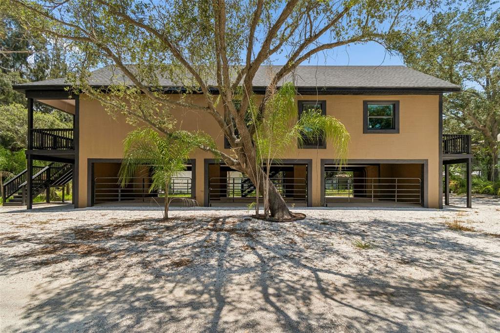 A two-story house with an elevated living area above an open-air ground level with stalls — 16288 48TH ST N, CLEARWATER, FL