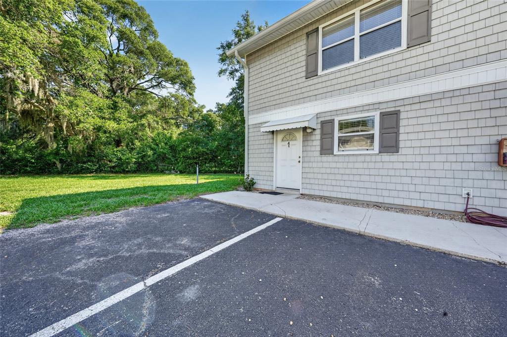 A two-story building with gray shingle siding, a white front door, and an asphalt driveway — 4420 CARTER ROAD UNIT 41, ST AUGUSTINE, FL