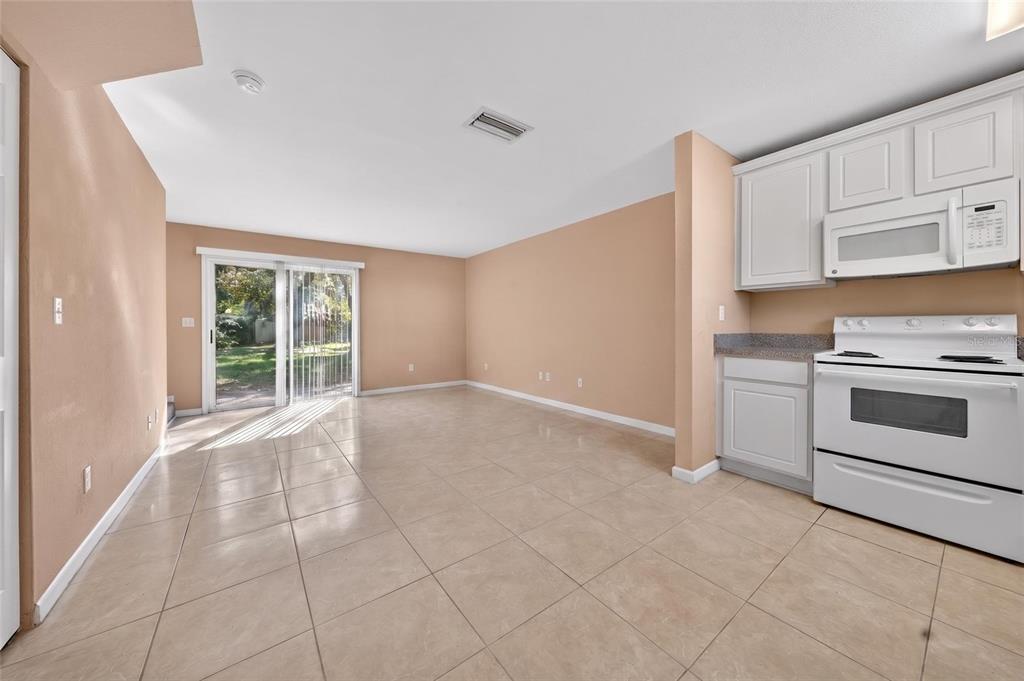 A kitchen with white cabinets, white appliances, and gray speckled countertops over tile flooring — 4420 CARTER ROAD UNIT 41, ST AUGUSTINE, FL
