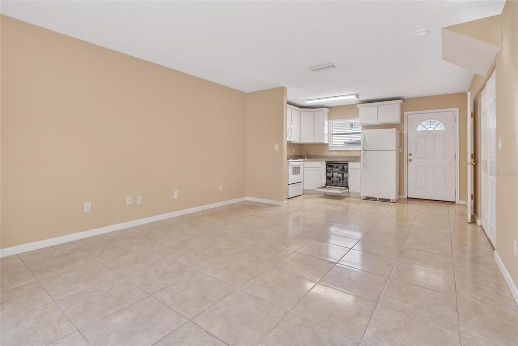 An open-concept kitchen and living area with beige walls and light-colored tile flooring — 4420 CARTER ROAD UNIT 41, ST AUGUSTINE, FL