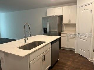 A kitchen with white cabinets, stainless steel appliances, and a central island with a sink — 30 PONY LANE UNIT A, PALM COAST, FL