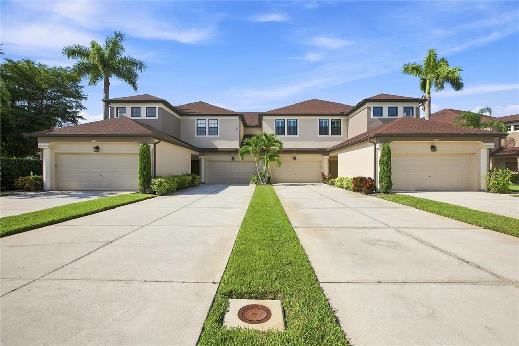 A two-story residential building features four garage doors and a shared concrete driveway — 3781 COSTA MAYA WAY UNIT 101, ESTERO, FL