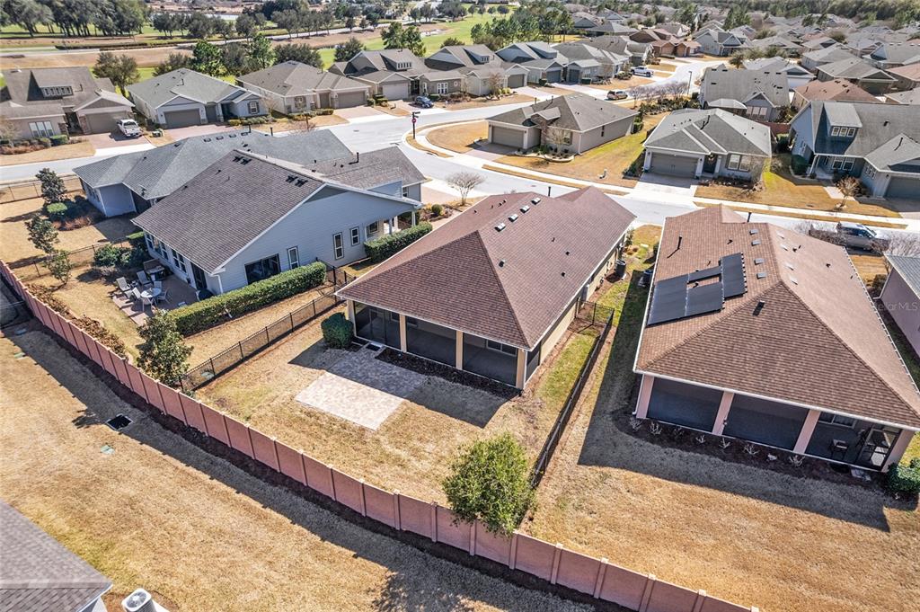 An aerial view shows a residential neighborhood with houses, fenced backyards, and paved patios — 5579 NW 40TH PLACE, OCALA, FL