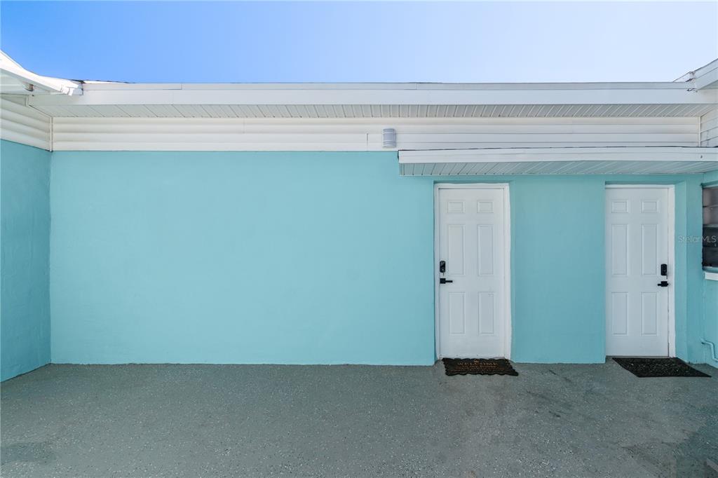 A turquoise exterior wall features two white doors with electronic locks under a white overhang — 804 13TH AVENUE S, ST PETERSBURG, FL
