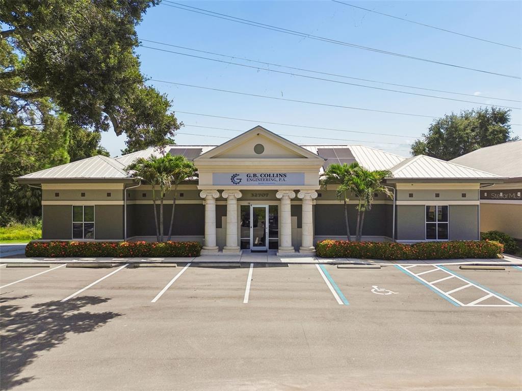The exterior of a single-story commercial building features a columned entrance and a parking lot — 32707 US HIGHWAY 19 N, PALM HARBOR, FL