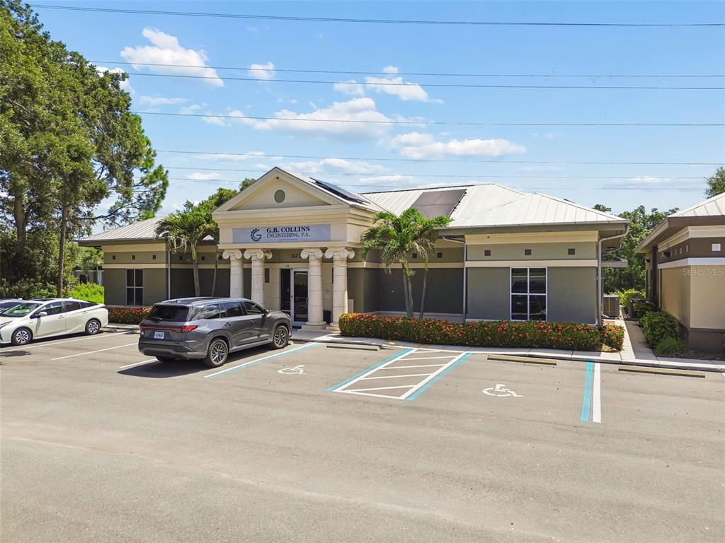 A single-story commercial building with a columned entrance and a parking lot in front — 32707 US HIGHWAY 19 N, PALM HARBOR, FL
