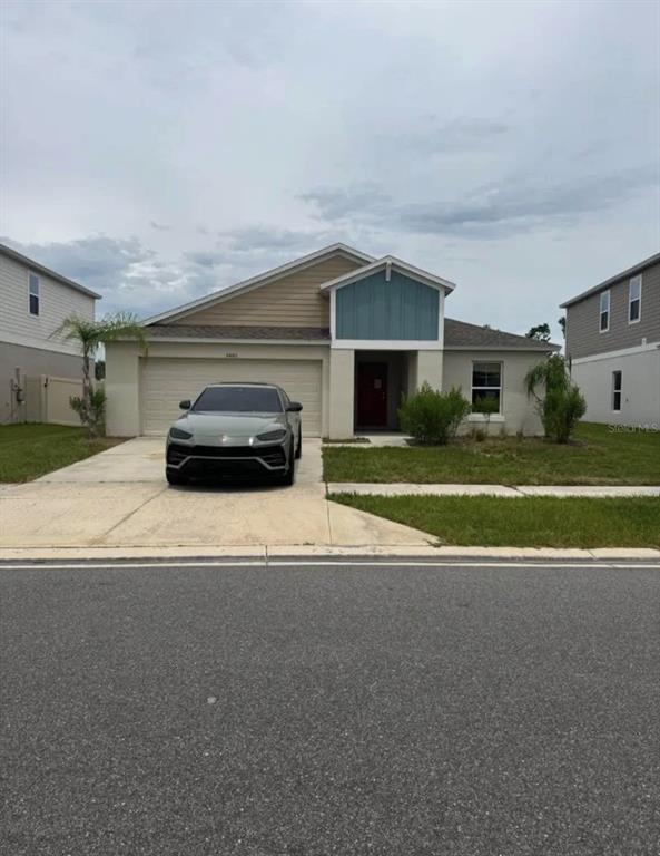 A single-story house with a beige and blue exterior and a car parked in the driveway — 5480 SILTSTONE STREET, LAKELAND, FL