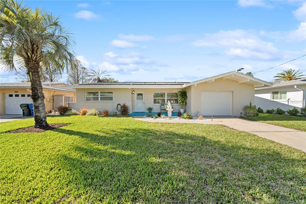 A single-story house with a white garage, a palm tree, and a landscaped front yard — 632 SHORE DRIVE, LARGO, FL