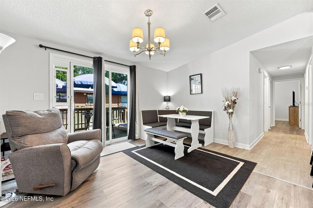 A dining area features a corner banquette, a white table, and a gray recliner — 905 SAINT JOHNS AVENUE, GREEN COVE SPRINGS, FL