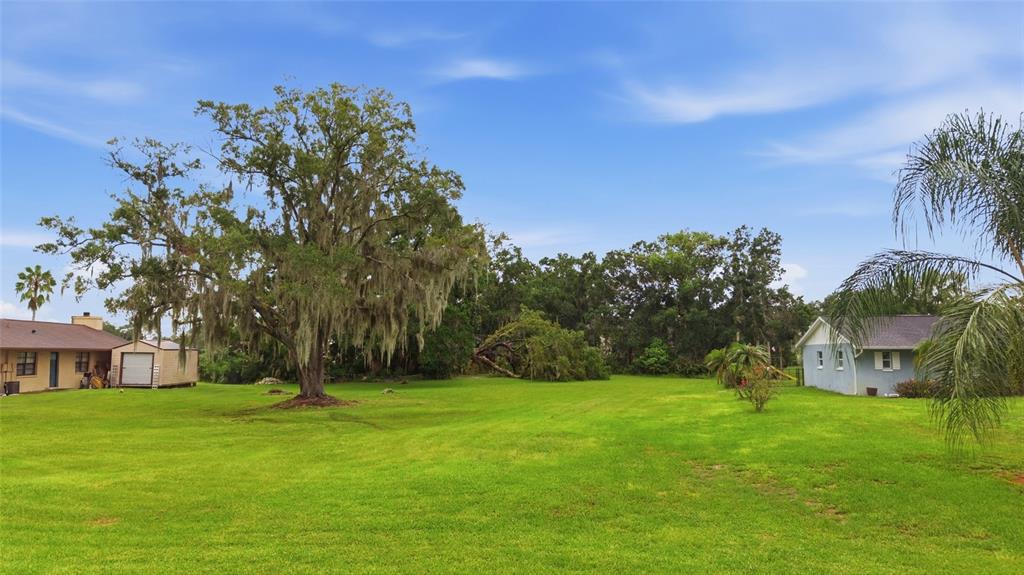An aerial view shows a grassy residential lot outlined in red next to a lake — 22506 SHORESIDE DRIVE, LAND O LAKES, FL