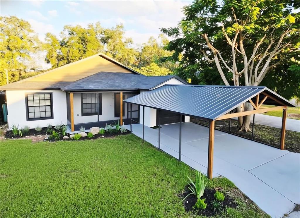 A single-story house with a white exterior, a dark metal roof, and a covered carport — 531 1ST AVENUE, ALTAMONTE SPRINGS, FL