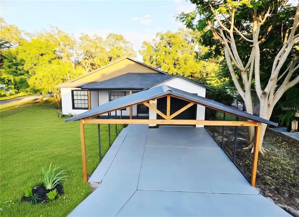 A house exterior features a gray metal carport structure over a concrete driveway — 531 1ST AVENUE, ALTAMONTE SPRINGS, FL