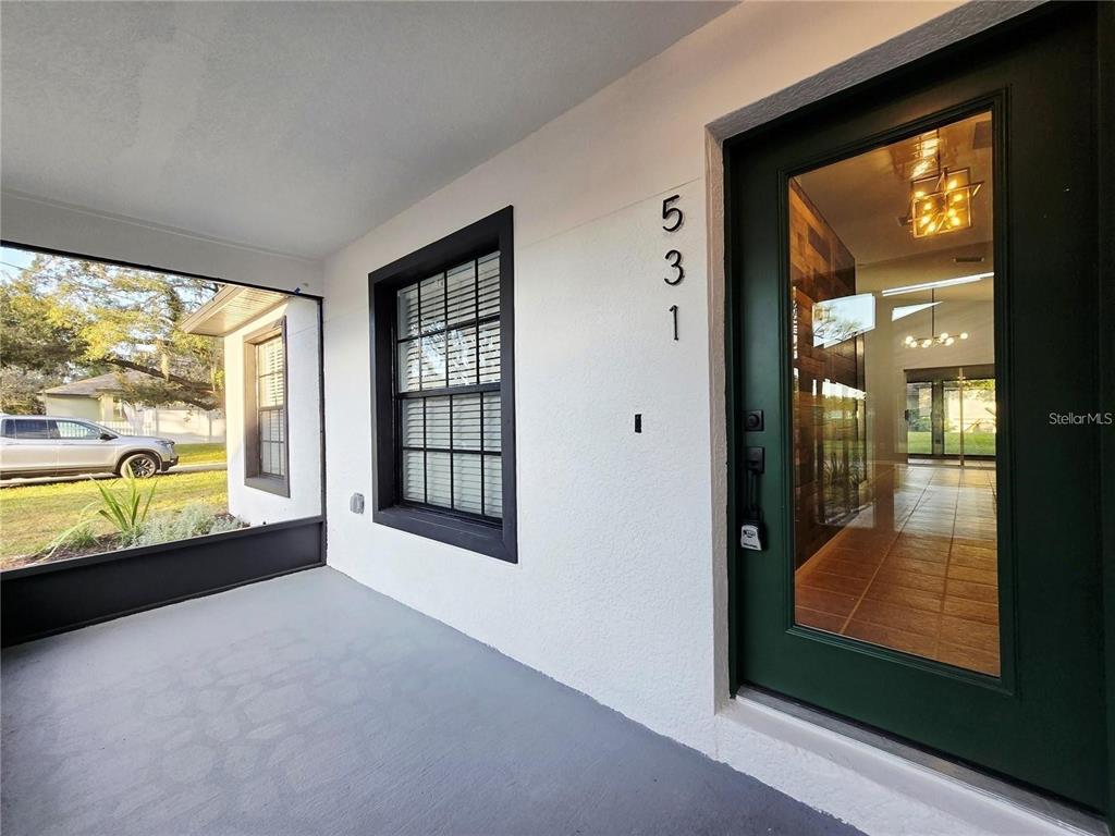 A covered porch features a dark-framed glass front door and a window with white blinds — 531 1ST AVENUE, ALTAMONTE SPRINGS, FL