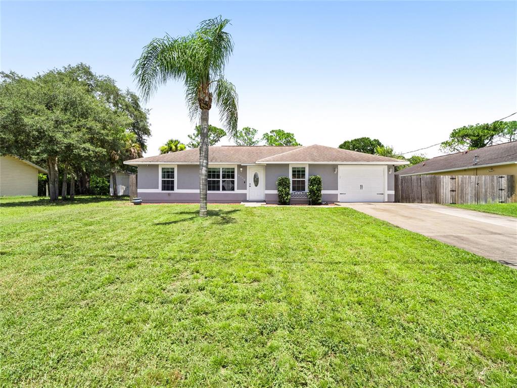 A single-story house with a gray exterior, a palm tree, and a concrete driveway — 4790 GREENHILL STREET, COCOA, FL
