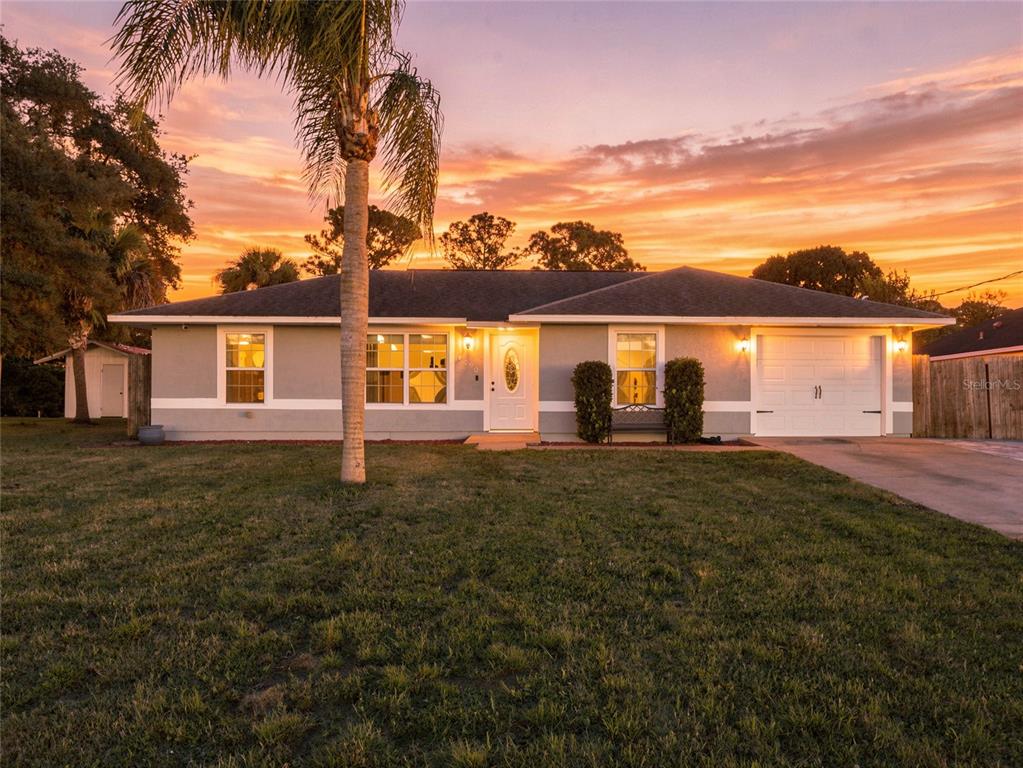 A single-story house with a palm tree in the front yard at sunset — 4790 GREENHILL STREET, COCOA, FL