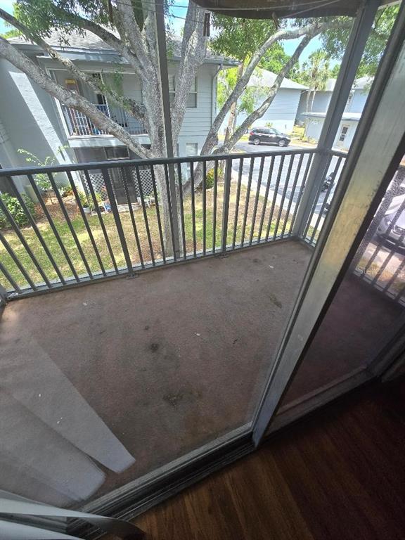 A balcony with a metal railing overlooks a parking lot and a neighboring apartment building — 10800 US HIGHWAY 19 N UNIT 237, PINELLAS PARK, FL