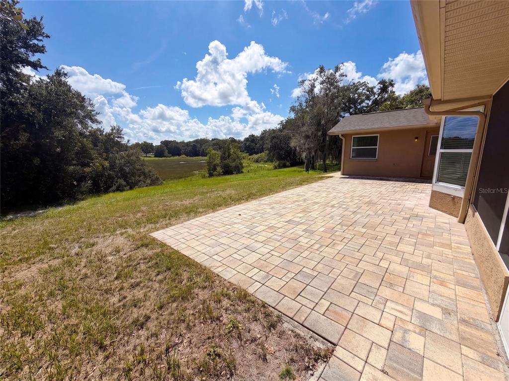 An open-concept living area features light-colored walls, wood-look tile flooring, and two ceiling fans — 4573 BAYRIDGE COURT, SPRING HILL, FL