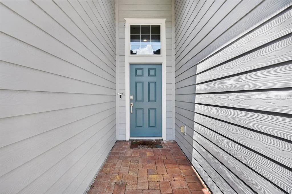 A blue front door with a transom window sits at the end of a brick walkway — 404 LAKE SINCLAIR STREET, ST AUGUSTINE, FL