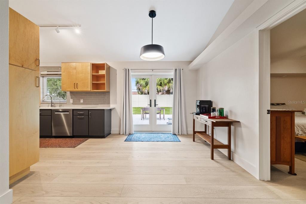 A kitchen with light wood cabinets and dark lower cabinets opens to a backyard patio — 12630 MAGNOLIA STREET, SAN ANTONIO, FL