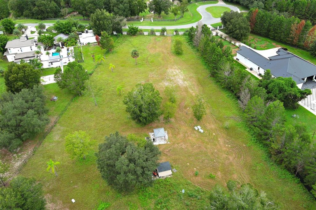 An aerial view shows a large, grassy residential lot with a small shed and gazebo — 34534 TREE FROG LANE, EUSTIS, FL