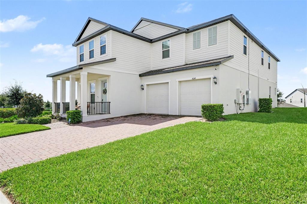 A two-story house with a white exterior, a two-car garage, and a brick paver driveway — 16260 SILVER GROVE BLVD, WINTER GARDEN, FL