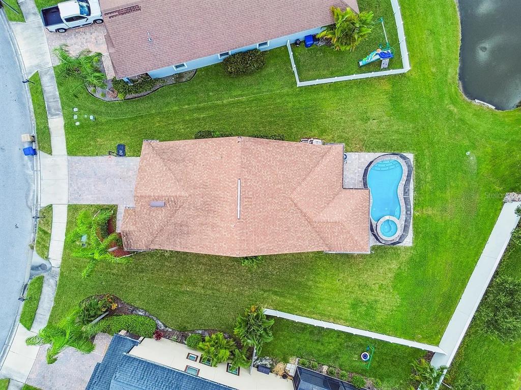An aerial view shows a house with a brown roof, a pool, and a large lawn — 11714 LAKE BOULEVARD, NEW PORT RICHEY, FL