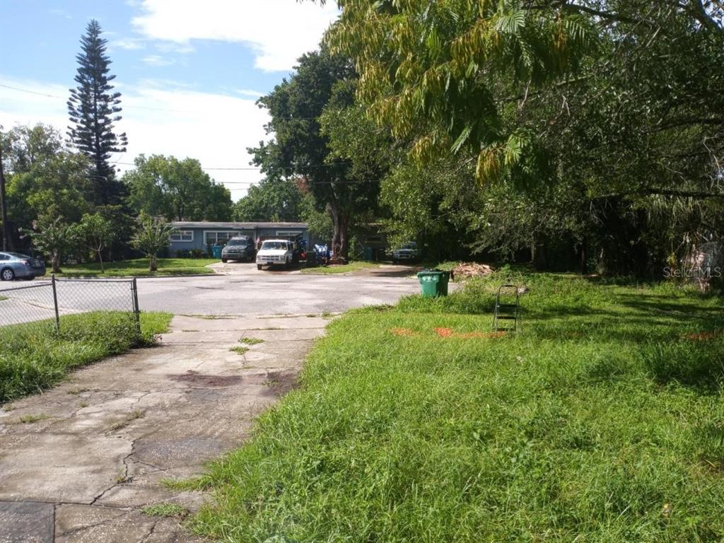 A paved driveway leads toward a residential property with trees and parked vehicles — 4022 SHELLMAN STREET, ORLANDO, FL