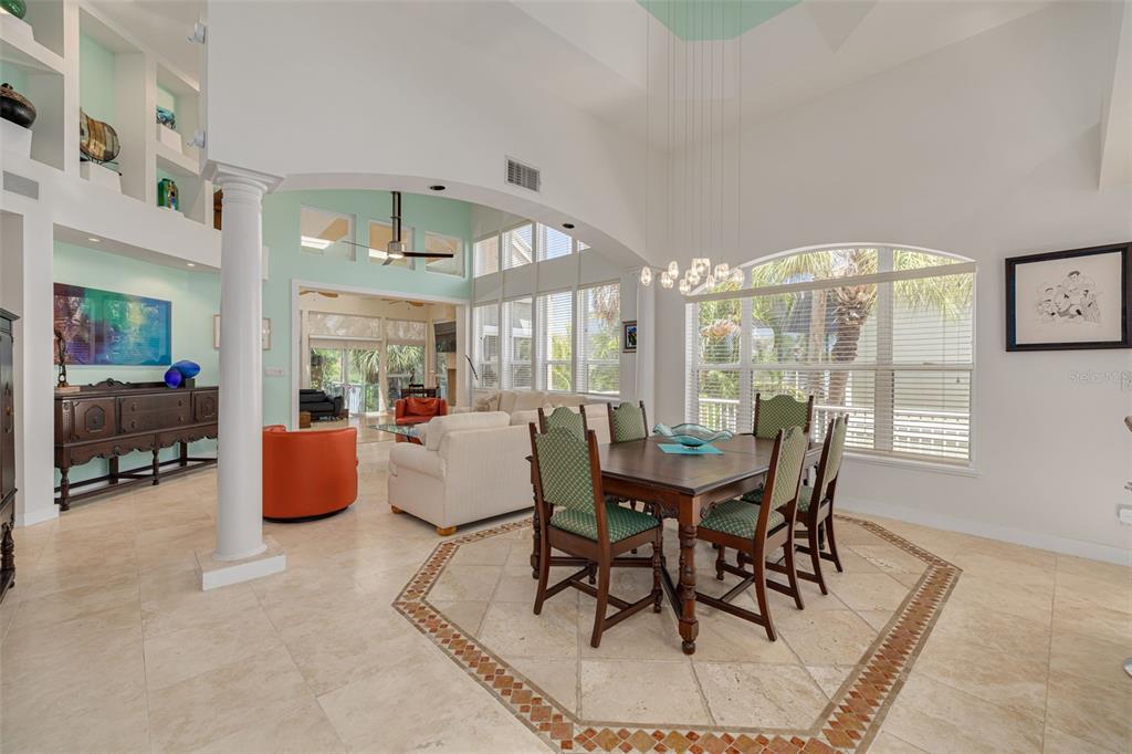 A dining area with a wooden table and chairs sits before a bright living room — 2613 59TH STREET S, GULFPORT, FL