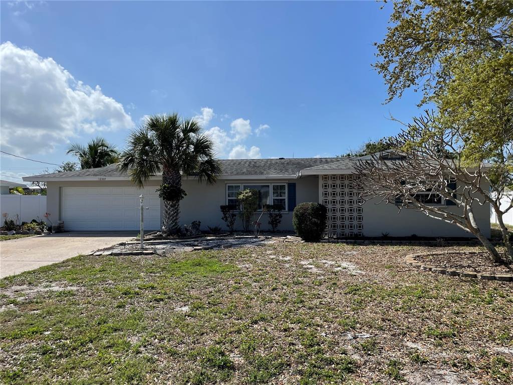 A single-story house with a two-car garage, a palm tree, and a decorative breeze block wall — 10307 SANDPIPER ROAD W, BRADENTON, FL