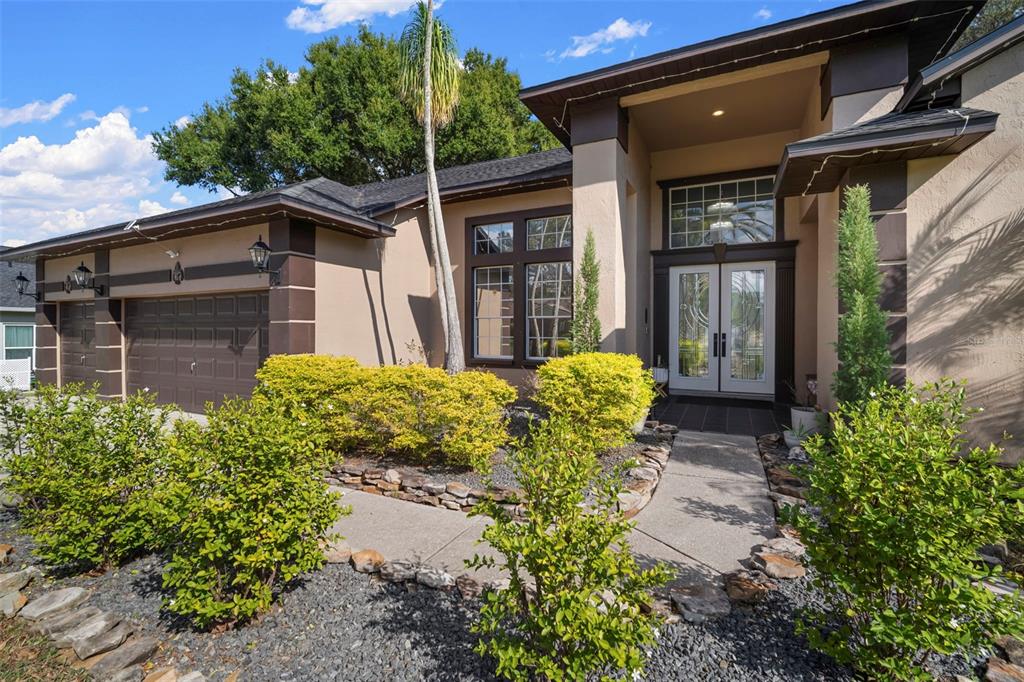 A single-story house with a brown garage, tan stucco walls, and a landscaped front yard — 424 SUMMIT CHASE DRIVE, VALRICO, FL