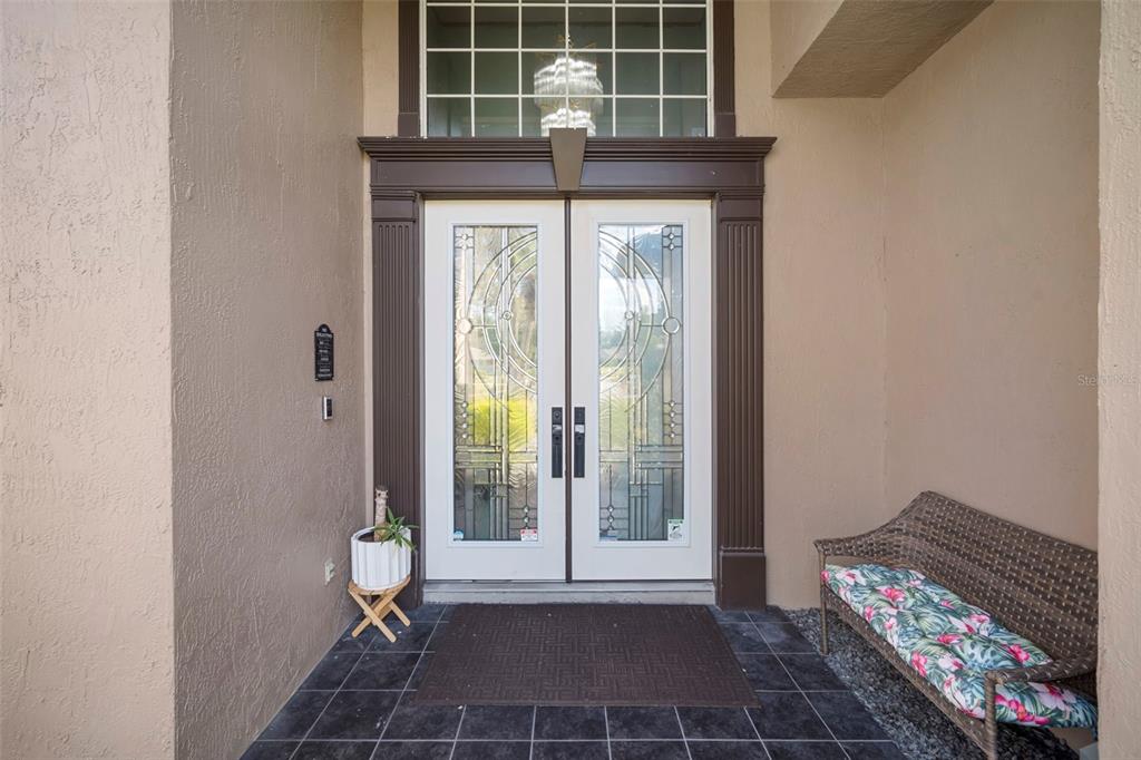 A front entryway features double glass-paneled doors, a dark tiled floor, and a wicker bench — 424 SUMMIT CHASE DRIVE, VALRICO, FL