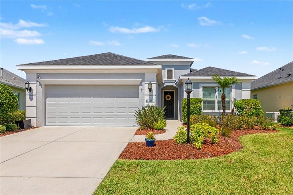 A single-story house features a gray stucco exterior, a two-car garage, and a landscaped front yard — 4213 PINE MEADOW DRIVE, PARRISH, FL